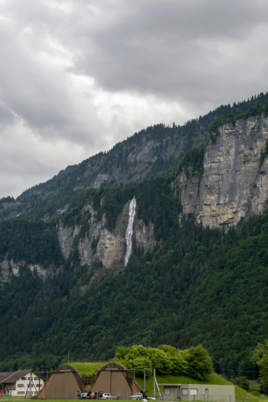 a large waterfall near many trees and buildings