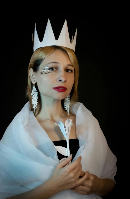 a woman with a crown on her head holding a feather