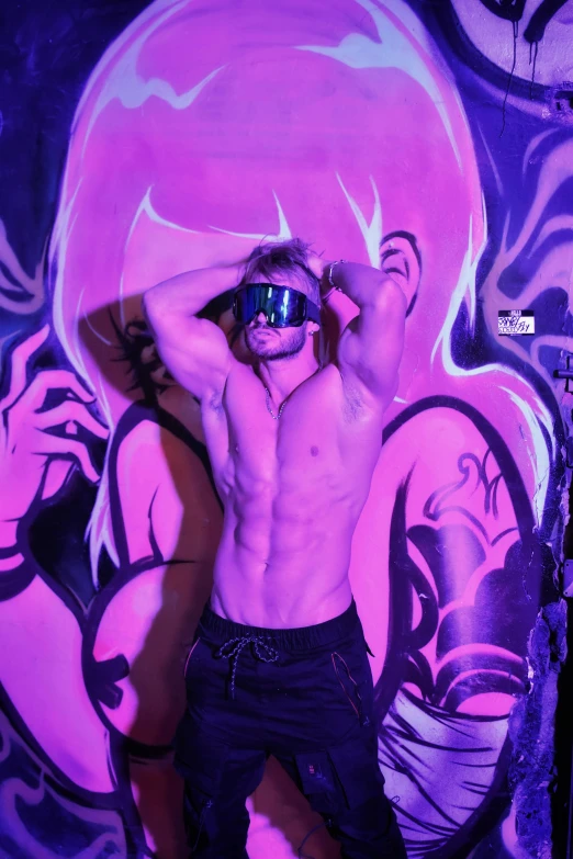 a shirtless man wearing a pair of dark blue glasses