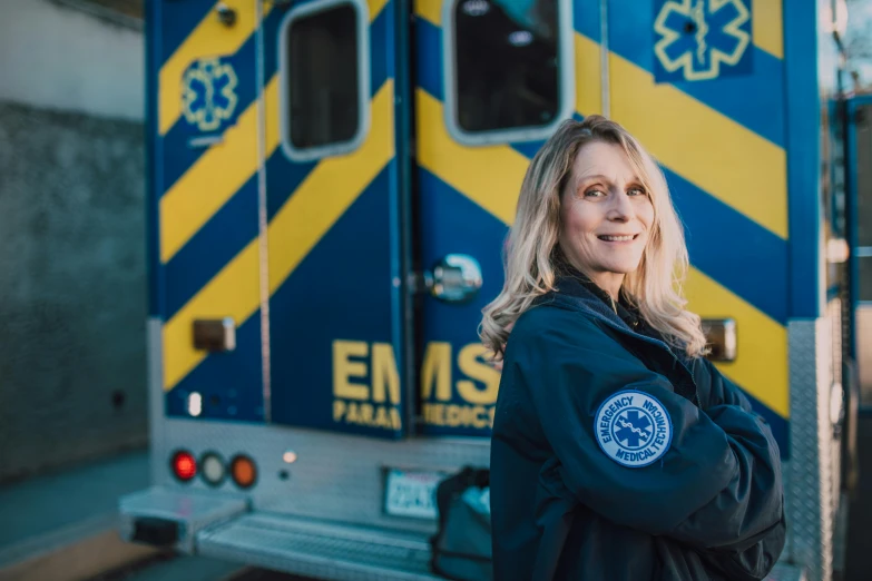 a woman standing in front of a ambulance