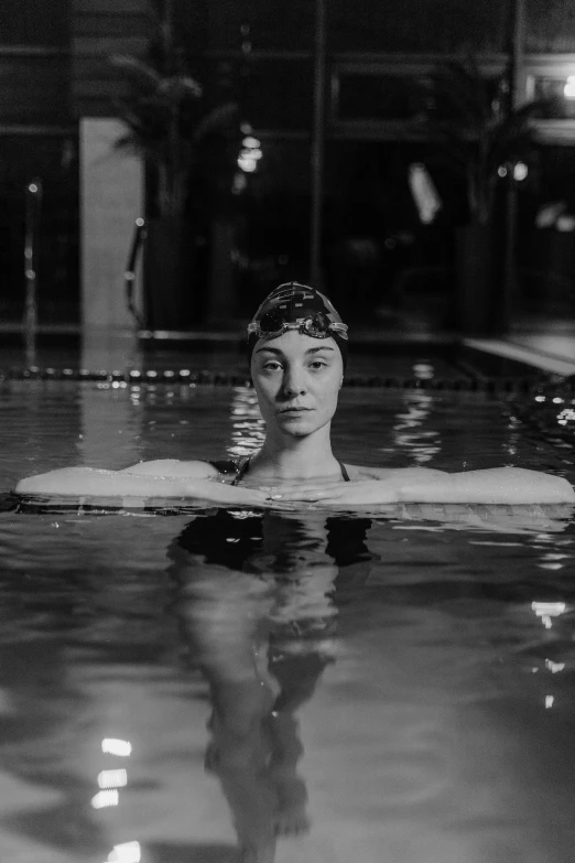 a woman floating in a swimming pool next to a building