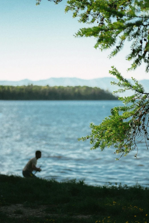 a person sitting next to a body of water