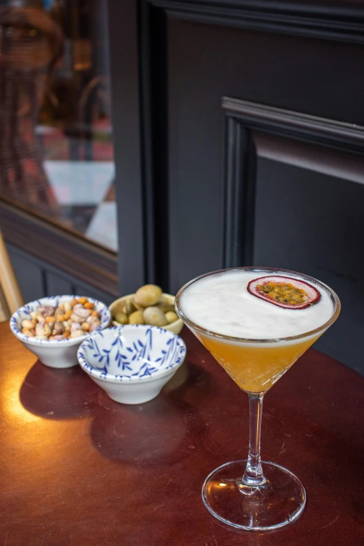 a tall glass sitting on a table filled with drinks