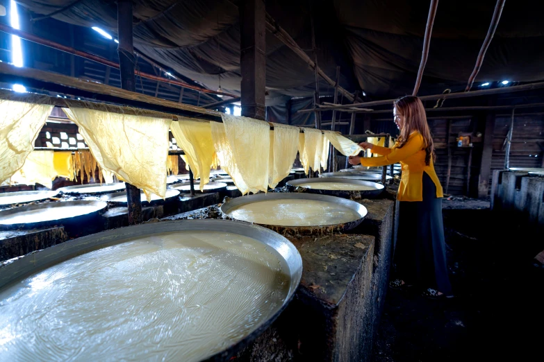 a woman stands in front of three white sinks