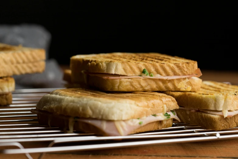 grilled sandwiches piled on top of each other on a table