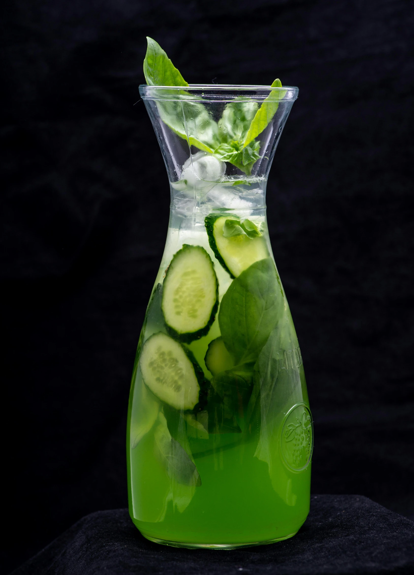 an iced beverage in a pitcher filled with cucumbers