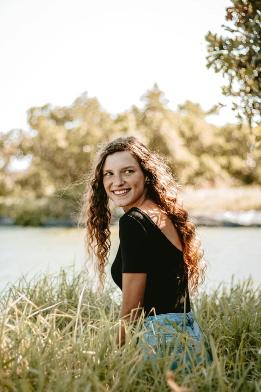 a woman posing for a po, next to some grass