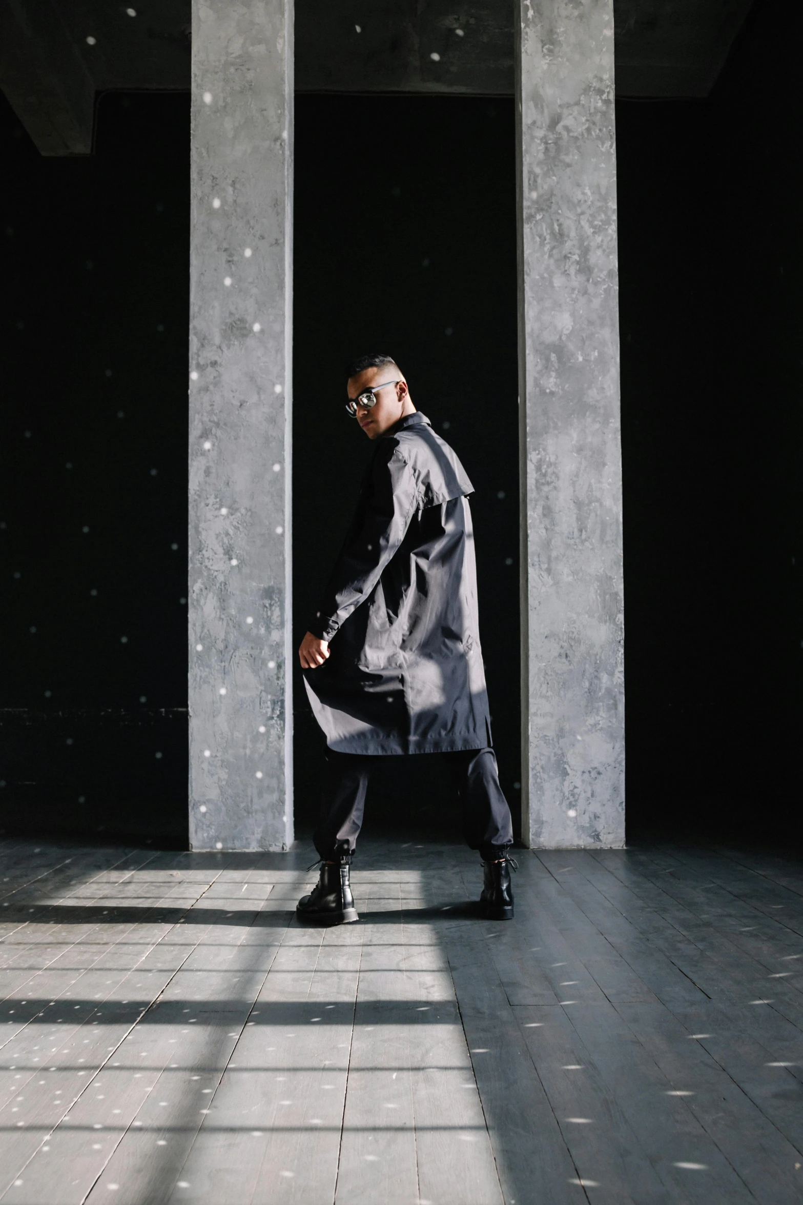 a man walking across a tiled floor holding onto an umbrella