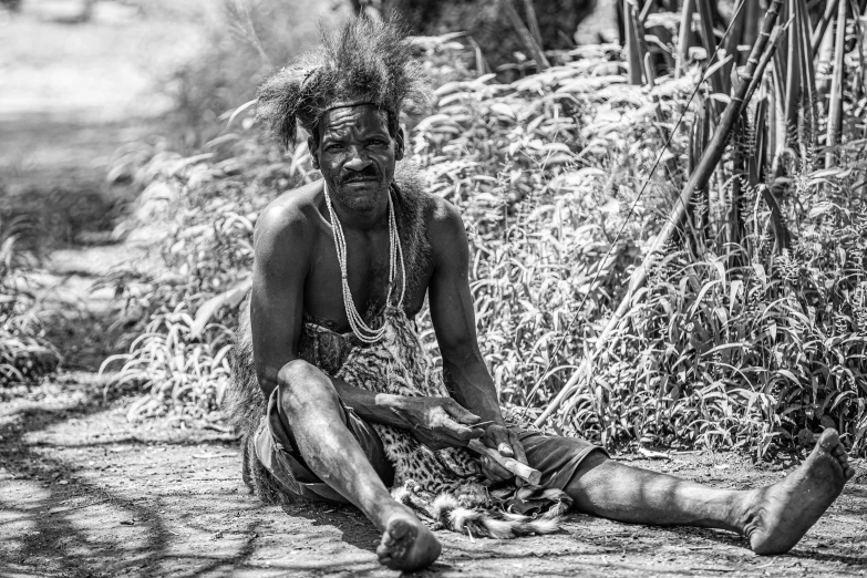 a man in an ethnic tribe sitting down on the ground