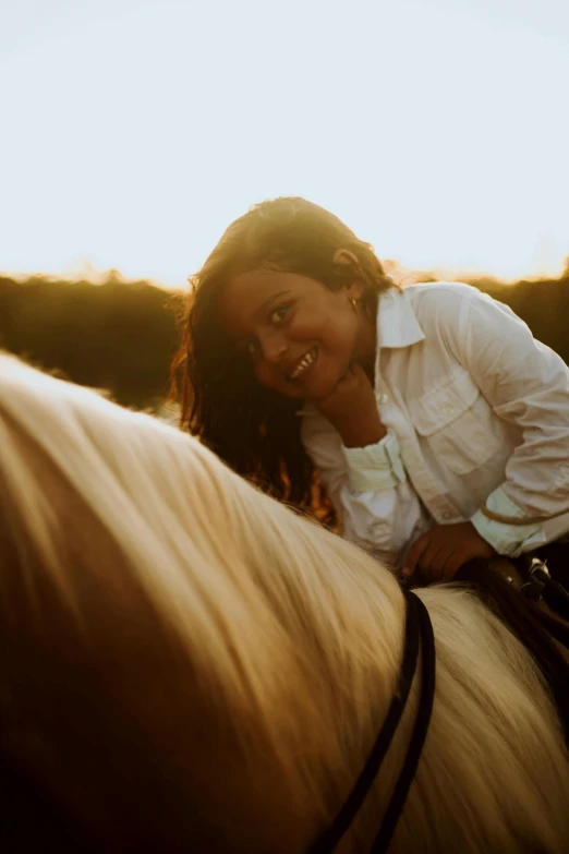 a woman wearing white shirt riding on the back of a horse