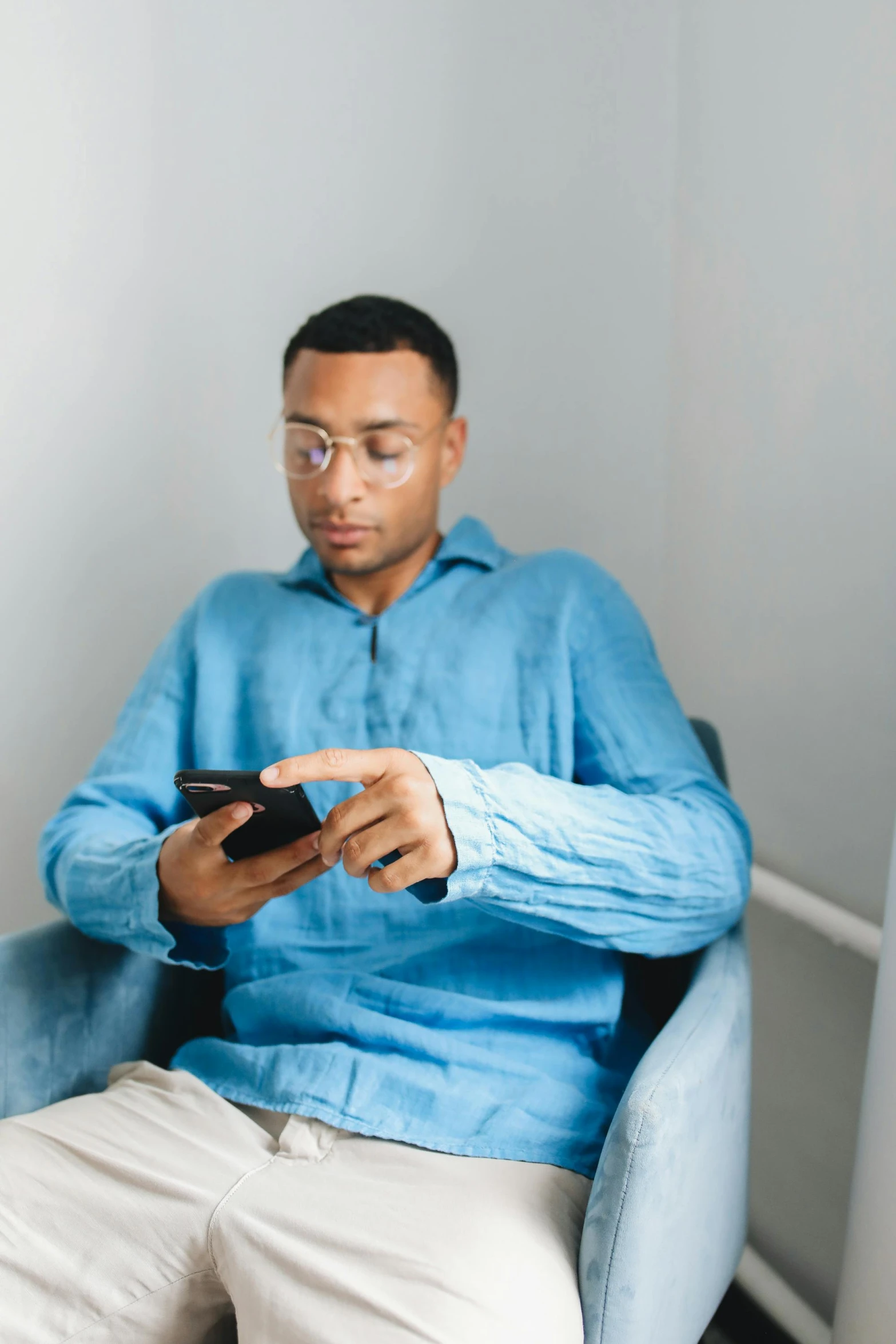 a man in a blue jacket holding a smart phone