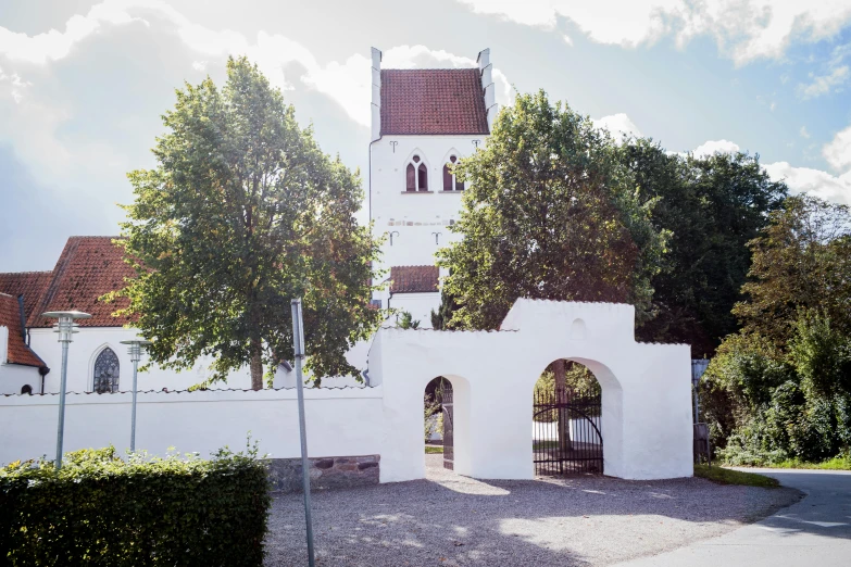 a white brick church with trees in the background