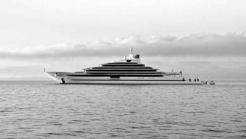 a large yacht sailing across the ocean on a cloudy day