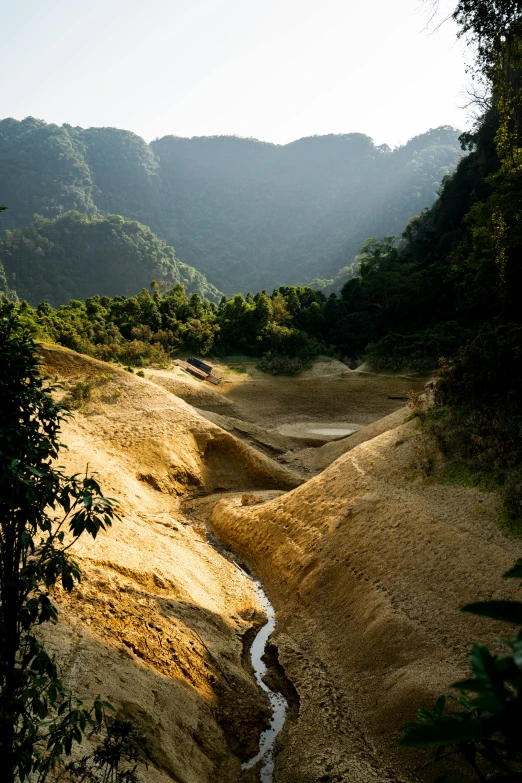 a wide view of a hilly area with a stream of water running