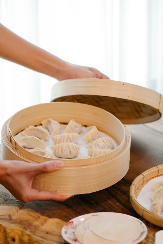 a man holding a large chinese dumpling container