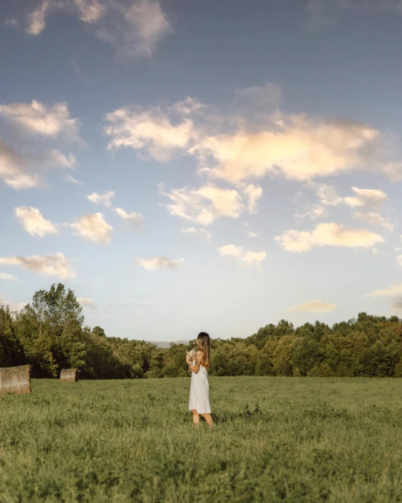 a woman standing in the middle of a field