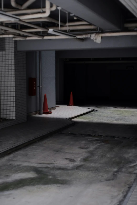 an empty garage with a parking sign and a cone