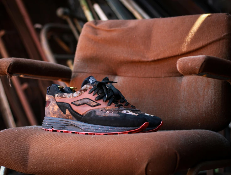 a pair of brown and black shoes sitting on an old chair