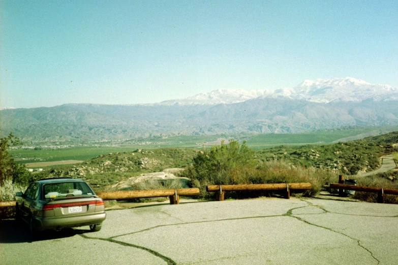 a car parked on a street in front of mountains