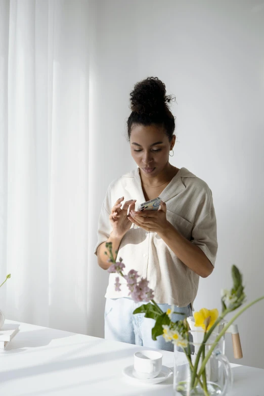 the woman holds a small object and looks at it