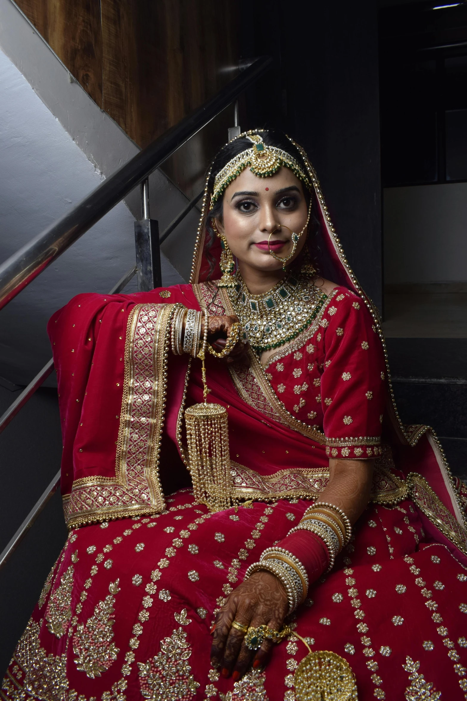 a woman is dressed in red and gold sitting