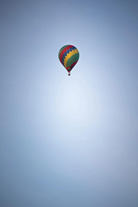 a colorful balloon flying in the air, with its sun just above