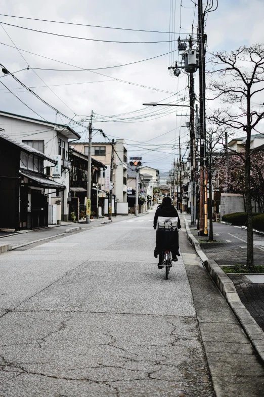 a man riding a bike down the middle of a street