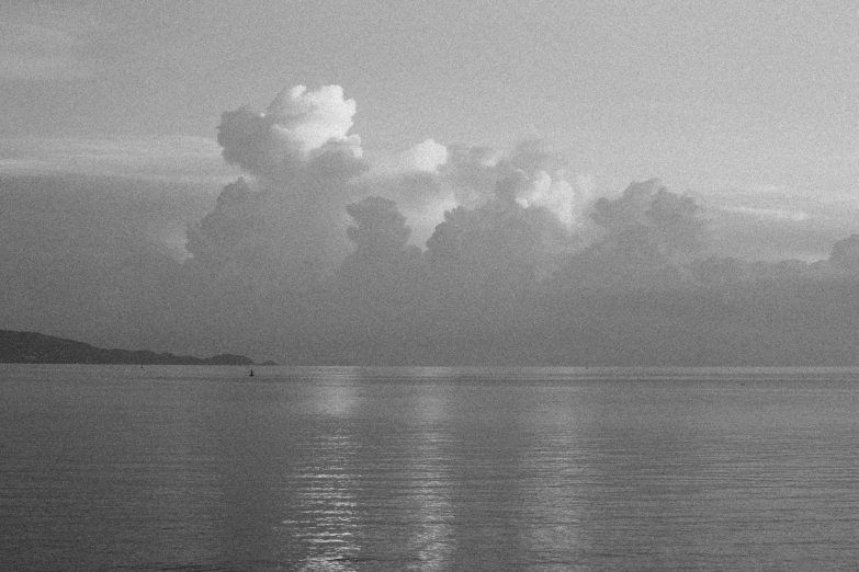 a boat in the ocean under a cloudy sky