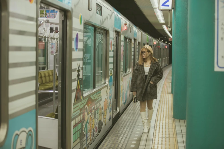 a woman stands on the side of a subway train