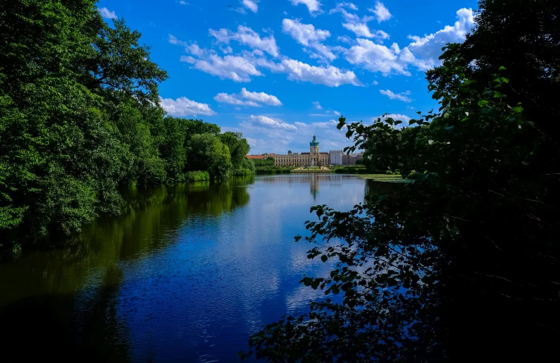 a body of water near many trees and buildings