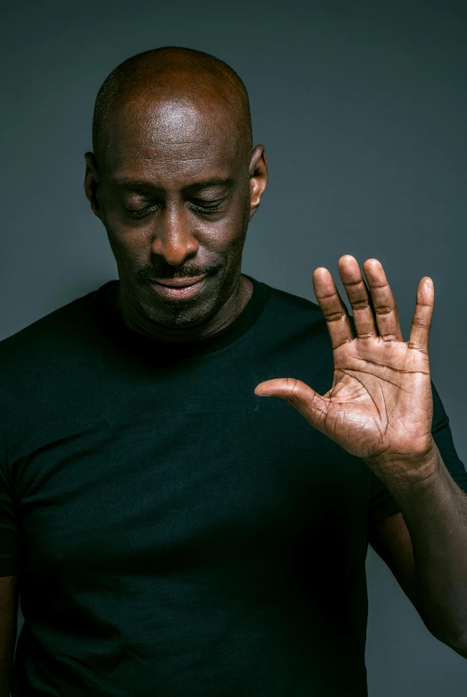 a man in black shirt holding his hand up