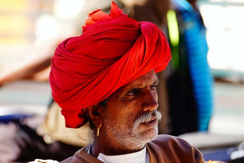 a man wearing a turban sitting on the street