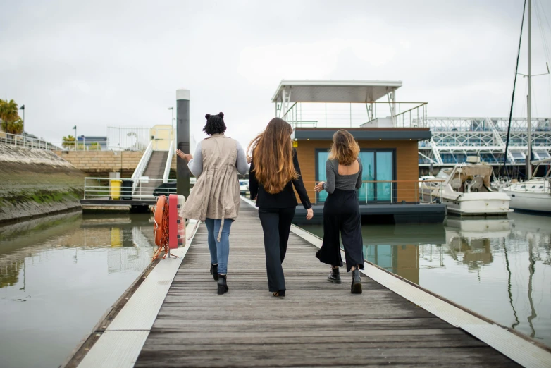 two girls walking hand in hand down a dock