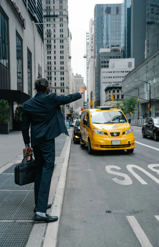 the man is walking in the street taking pictures of taxi