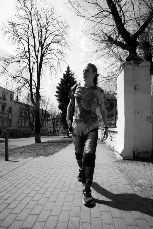 a man is walking down a sidewalk with his back to the camera