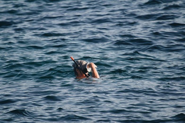 a person with a surfboard in the middle of the ocean