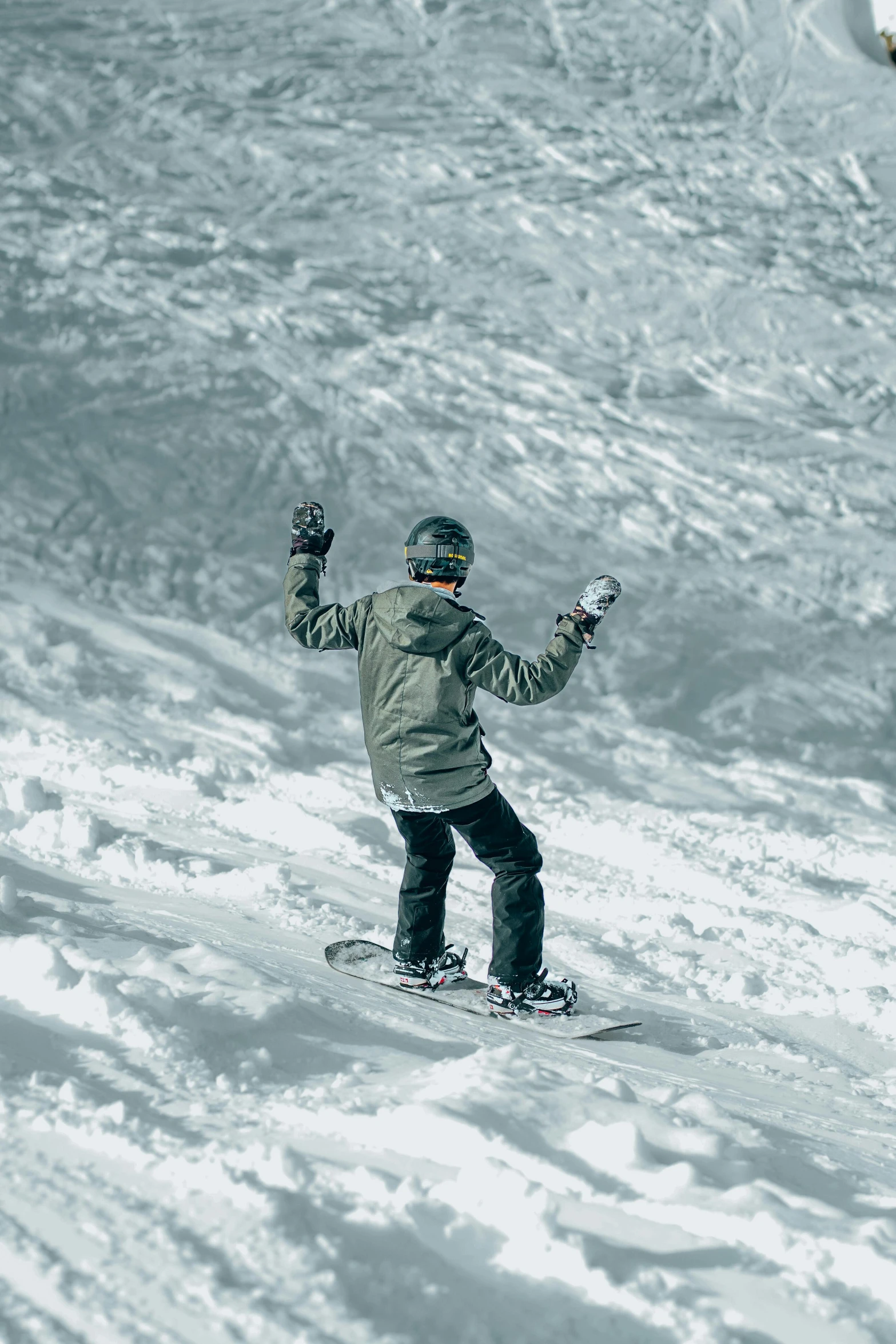 a man riding a snowboard down the side of a mountain