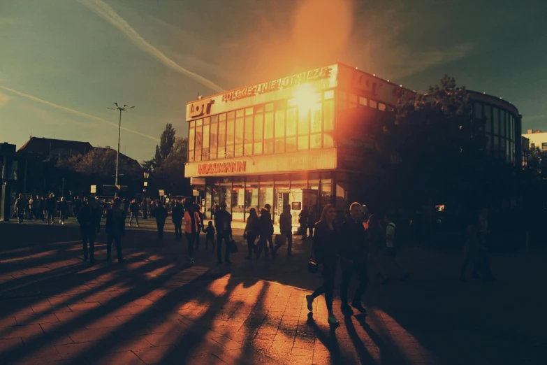 group of people standing in the shadow on a sidewalk