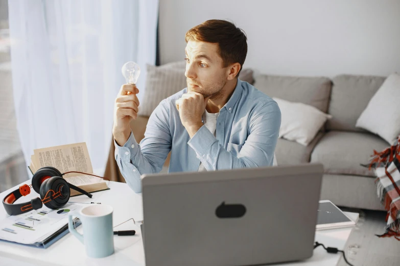 a man sitting at a table with his laptop computer