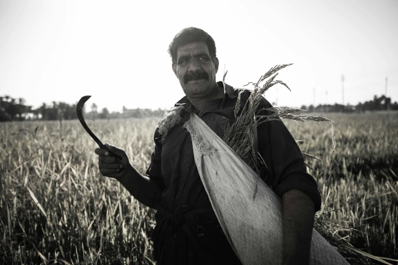 an old man holding an axe in his hand in a field