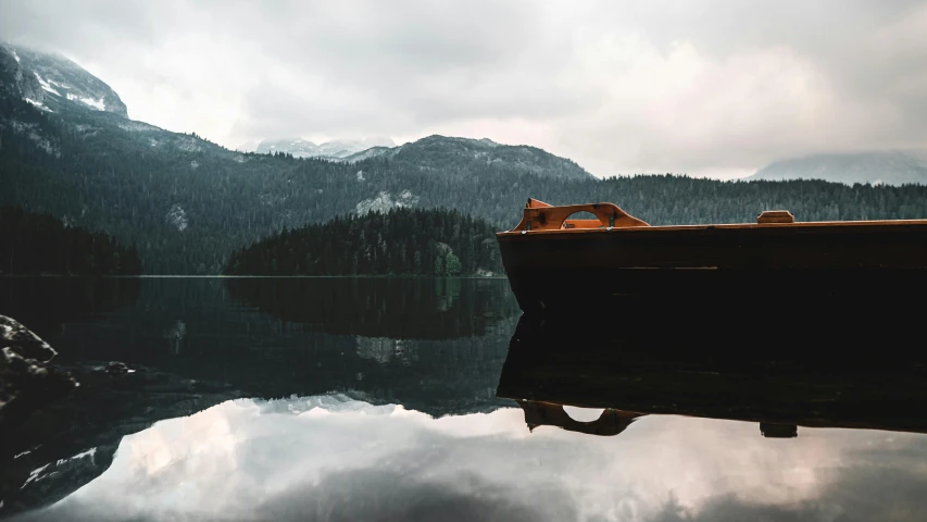 the boat is in the water on a cloudy day