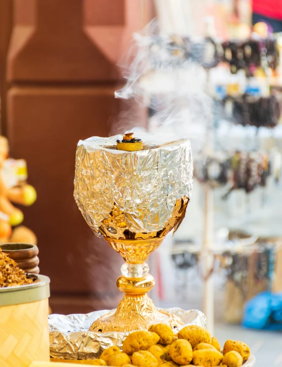 a cup with a golden top surrounded by other items