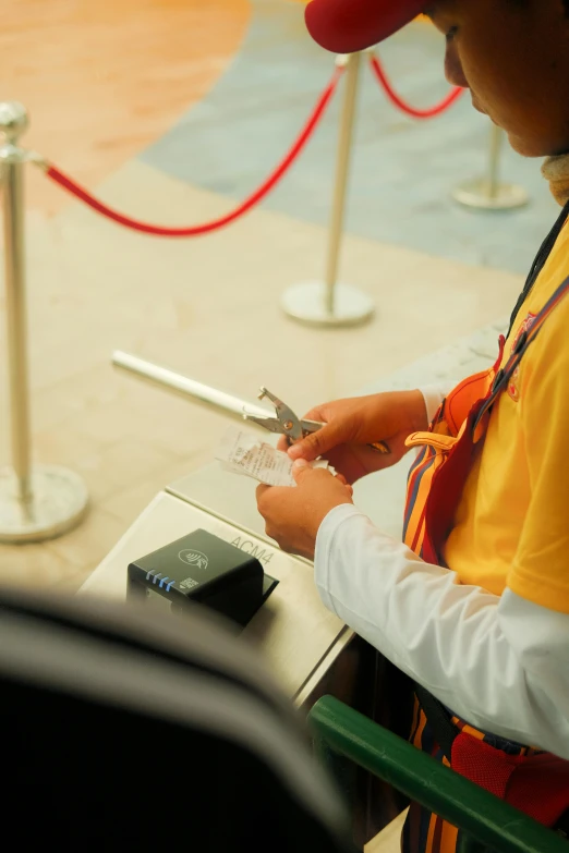 there is a man sitting at an airport counter  a paper