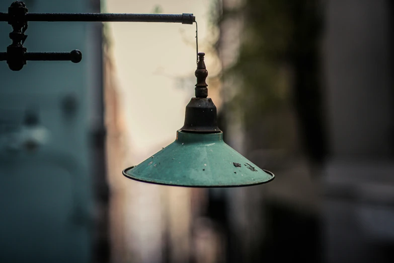 a small metal hanging light fixture with green tin