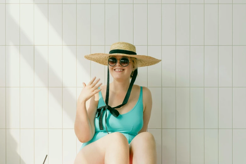 a young woman wearing a hat and wearing a swimsuit