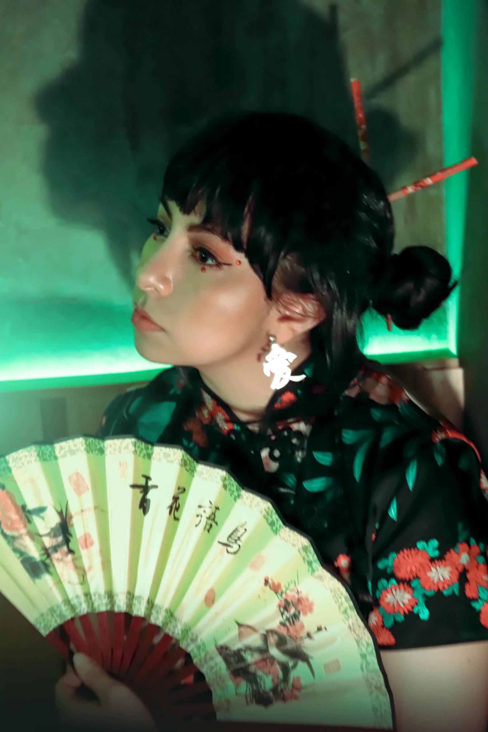 a lady holding a hand fan against a wall