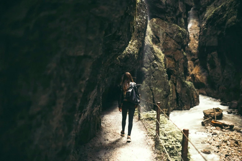 a person with a backpack walks through an ancient cave