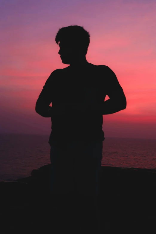 a man standing on the side of the ocean