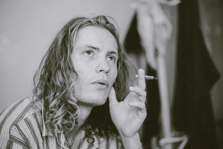 black and white pograph of a person holding up a cigarette