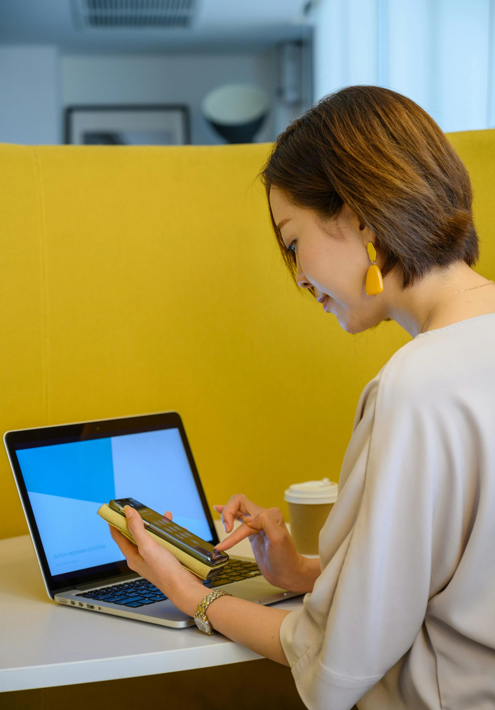 woman using laptop and yellow wall with windows